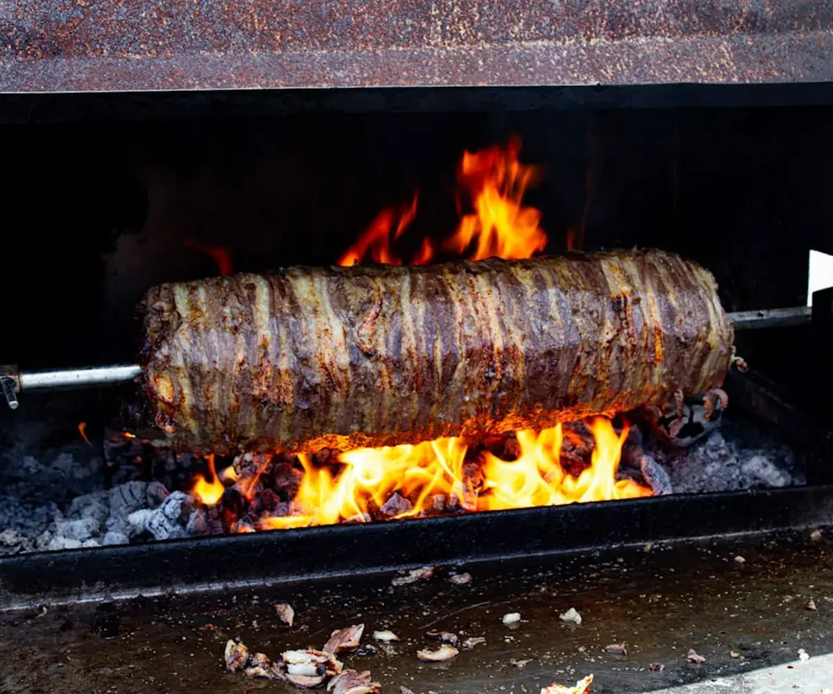 Meat roasting on a spit over open flame